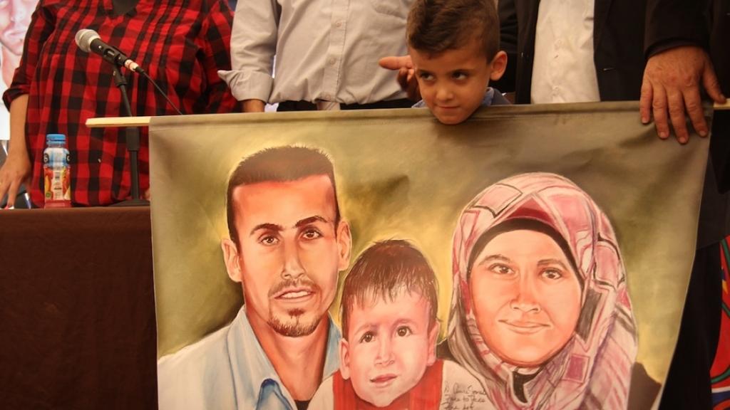 Israelíes se burlan fuera del juzgado de la familia de un bebé palestino asesinado en 2015 por un incendio provocado.